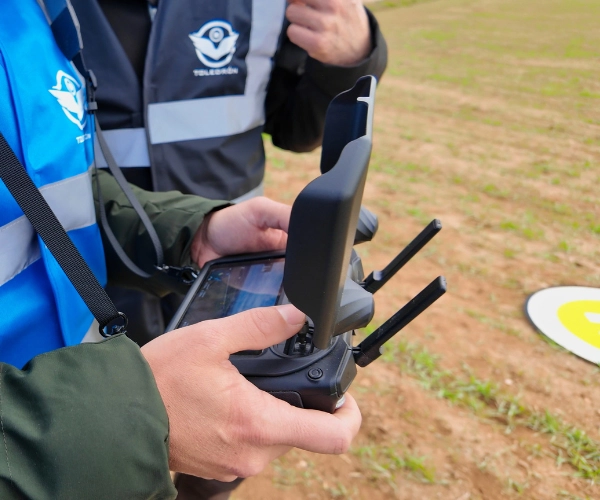 Piloto de drones sujetando una emisora realizando un curso