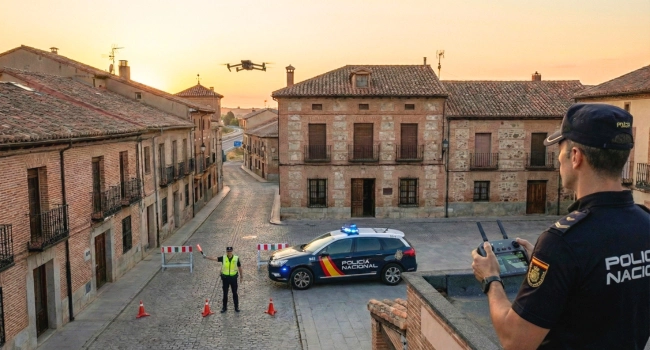 policia-nacional-uso-dron-control-trafico-toledo Agente de la Policía Nacional pilotando un dron DJI Enterprise desde una azotea para supervisar un control de tráfico en un pueblo al atardecer.